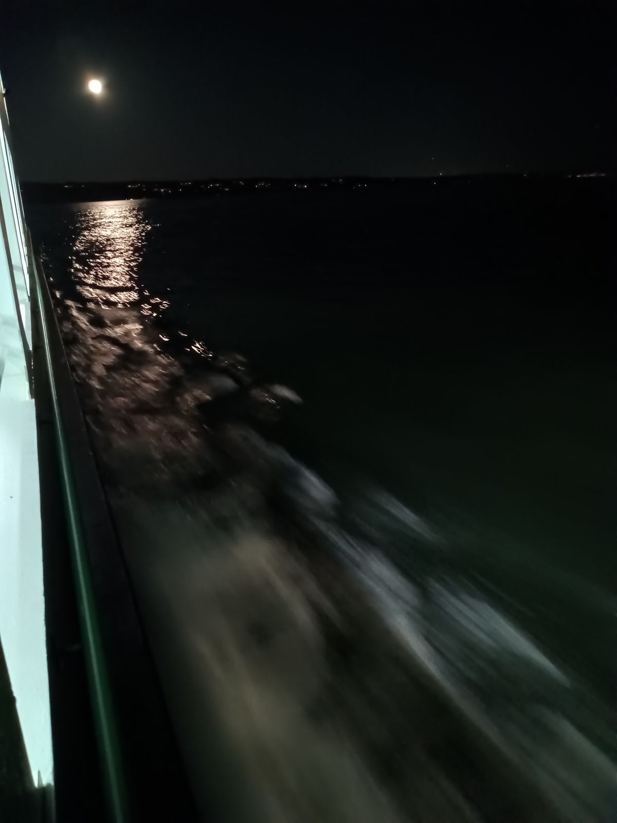 Full moon rising behind a moving ferry, July 2023.